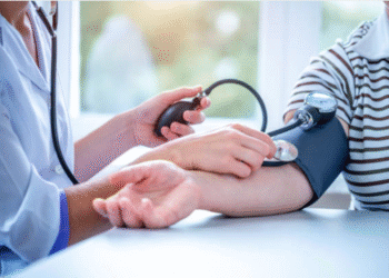 gambr ini berisikan orang yang sedang di cek tensinya menggunakan alat kesehatan